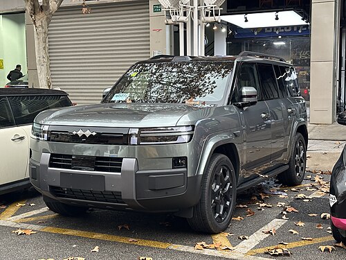 Fangchengbao Ti7 สีเทาเขียว มุมหน้าเฉียง จอดริมถนนในจีน (ภาพรุ่นปลั๊กอินไฮบริด ปี 2025)