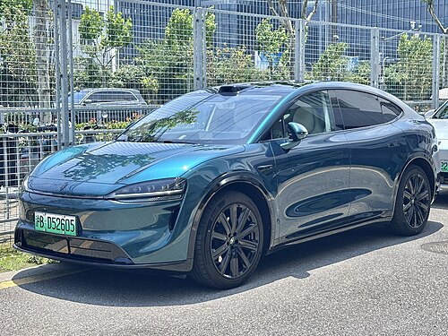 Luxeed R7 รุ่นปรับโฉมปี 2025 สีเขียวอมฟ้า มุมหน้าเฉียง จอดริมถนนในจีน