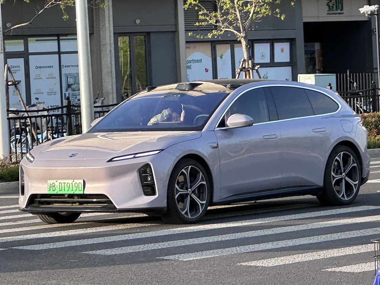 Nio ET5T รุ่นปรับโฉม สีเงิน มุมหน้าเฉียงเห็นทรงสเตชันแวกอน บนถนนในจีน