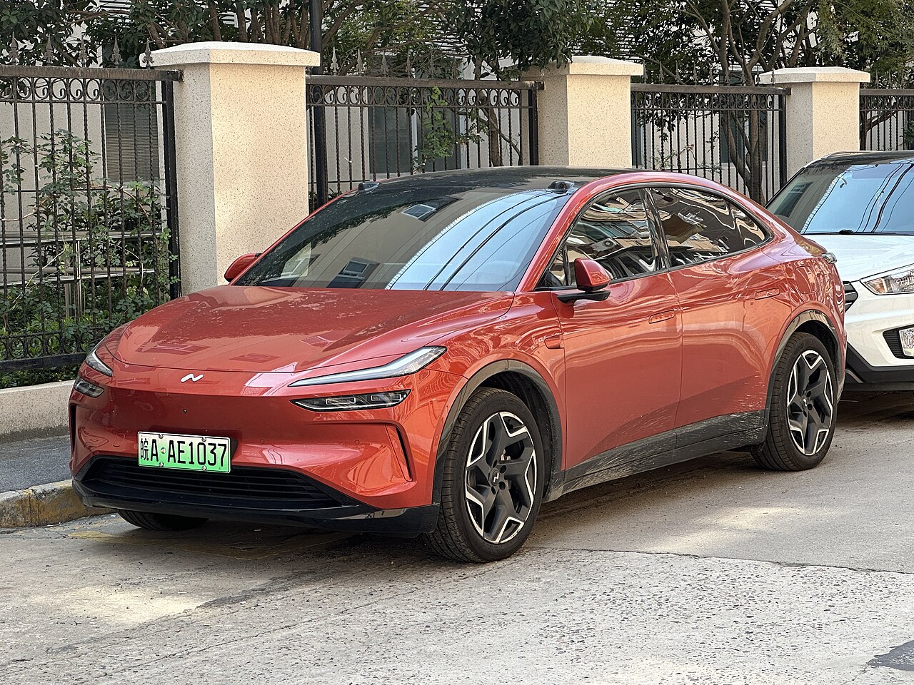 Onvo L60 (รุ่นปี 2024 ก่อนปรับปรุง) สีส้มแดง มุมหน้าเฉียง จอดริมถนนในจีน