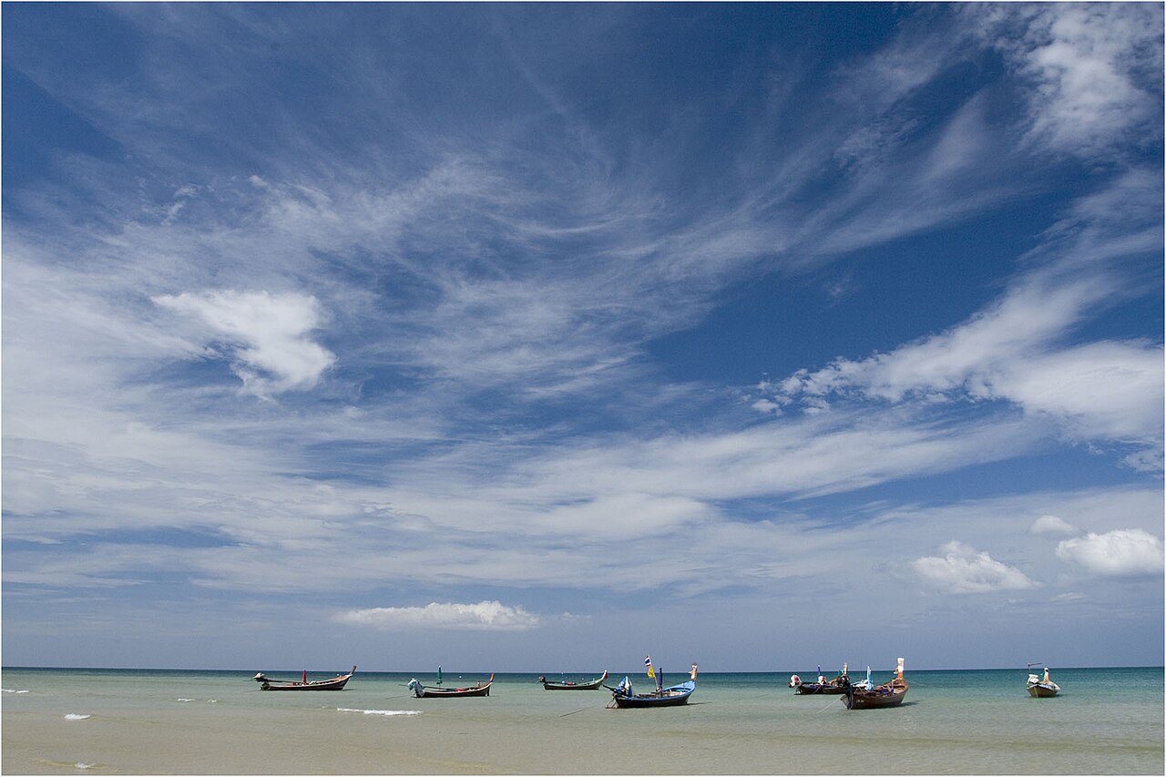 เรือหางยาวจอดลอยลำในอ่าวหาดกมลา ภูเก็ต ใต้ท้องฟ้าโปร่ง