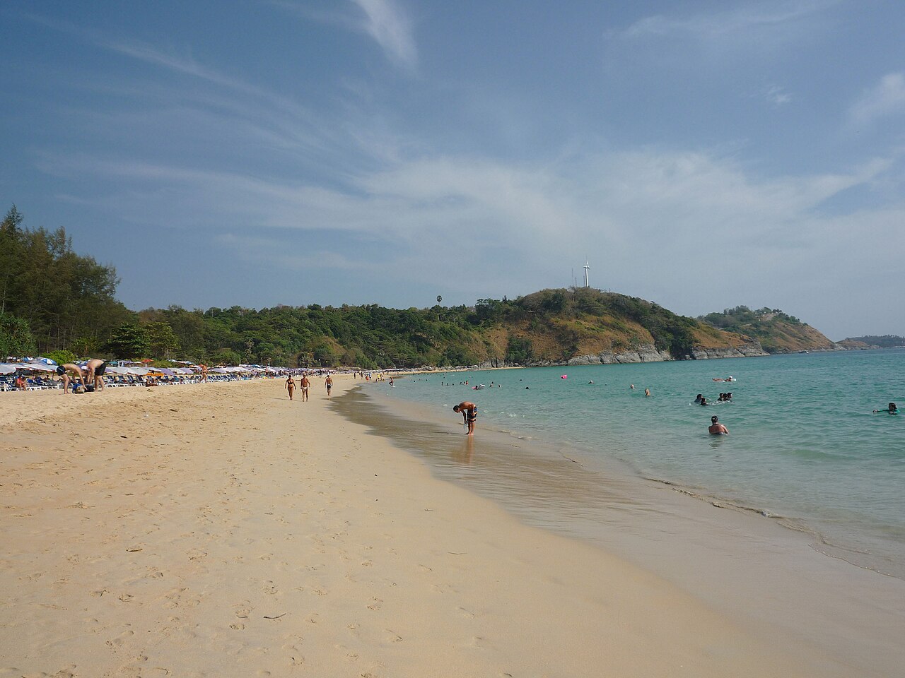 หาดในหาน ภูเก็ต ทรายขาวยาวโค้งไปทางเนินเขาที่มีกังหันลม